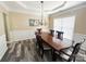 Elegant dining room with wainscoting, modern chandelier, and wood-look flooring at 9792 Ravenscroft Nw Ln, Concord, NC 28027