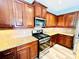 Well-lit kitchen featuring stainless steel appliances, granite countertops, and wood cabinets at 9792 Ravenscroft Nw Ln, Concord, NC 28027