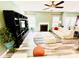 A modern living room with a fireplace, ceiling fan, stylish decor, and wood floors at 9792 Ravenscroft Nw Ln, Concord, NC 28027