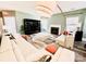 A modern living room with a fireplace, ceiling fan, stylish decor, and wood floors at 9792 Ravenscroft Nw Ln, Concord, NC 28027