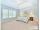 Spacious main bedroom with tray ceiling, large windows, and neutral carpet at 9792 Ravenscroft Nw Ln, Concord, NC 28027