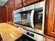 A stainless steel microwave is installed above a range and is accented by natural countertops at 9792 Ravenscroft Nw Ln, Concord, NC 28027