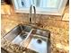 This kitchen sink features stainless steel basins, an industrial style faucet, and granite countertops at 9792 Ravenscroft Nw Ln, Concord, NC 28027