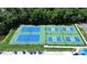 Overhead view of well-maintained tennis courts surrounded by lush greenery at 9792 Ravenscroft Nw Ln, Concord, NC 28027
