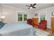Comfortable bedroom features a ceiling fan, wooden floors, and cozy armchairs by bright windows at 1006 Home Trl, Gastonia, NC 28052