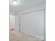 This bedroom has carpet, a light, and a double-door closet for storage at 1011 Atherstone Nw St, Conover, NC 28613