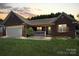 Charming brick home featuring an attached garage and inviting front porch at 1011 Atherstone Nw St, Conover, NC 28613
