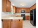 Bright kitchen featuring wood cabinets, black appliances, and tile flooring at 1011 Atherstone Nw St, Conover, NC 28613