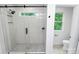 Modern bathroom featuring a glass enclosed shower with marbled tile, pebble floor, and a window at 1011 Sandy Ct, Gastonia, NC 28056