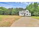 Spacious two-story home with white siding, black accents, long driveway, and surrounded by lush greenery at 1011 Sandy Ct, Gastonia, NC 28056
