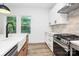 Bright kitchen features white cabinetry, stainless steel appliances, farmhouse sink, and natural light at 1011 Sandy Ct, Gastonia, NC 28056