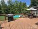 Inviting backyard showcases a wooden deck with grill, a gazebo, and a refreshing pool, perfect for outdoor activities at 103 Northchase Dr, Concord, NC 28027