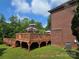 Large wooden deck featuring an umbrella covered seating area, adjacent to a brick home at 103 Northchase Dr, Concord, NC 28027