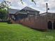 Wooden deck overlooking a lush backyard with mature trees, and a brick home at 103 Northchase Dr, Concord, NC 28027