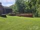 Inviting backyard featuring a wooden deck, manicured lawn, and mature shade trees at 103 Northchase Dr, Concord, NC 28027
