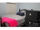 Comfortable bedroom with chevron bedding, and ample storage space with a built-in closet and storage containers at 103 Northchase Dr, Concord, NC 28027
