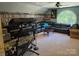 Large entertainment room with black leather sofa, round window, and built-in bookshelves for relaxation at 103 Northchase Dr, Concord, NC 28027