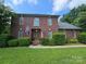 Beautiful brick home featuring a well-maintained lawn, manicured hedges, and classic architectural details at 103 Northchase Dr, Concord, NC 28027