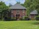 Charming brick two-story home featuring manicured lawn and traditional architectural details at 103 Northchase Dr, Concord, NC 28027