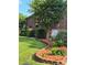 Brick home with landscaped yard featuring beautiful flowers, shrubs, and manicured lawn at 103 Northchase Dr, Concord, NC 28027