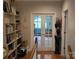 Bright hallway with hardwood floors, glass panel doors, and a bookshelf adds charm to the home's interior at 103 Northchase Dr, Concord, NC 28027