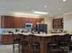 Spacious kitchen boasts bar seating, wooden cabinetry, and modern appliances for cooking convenience at 103 Northchase Dr, Concord, NC 28027