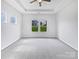 Cozy bedroom with a tray ceiling, neutral carpet, and natural light at 10328 Kempsford Dr, Charlotte, NC 28262