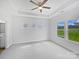 Bright bedroom features neutral carpet, a ceiling fan, and three windows at 10328 Kempsford Dr, Charlotte, NC 28262