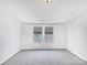 Bright, empty bedroom with carpeted floors, white walls, and a large window at 10328 Kempsford Dr, Charlotte, NC 28262