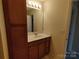 Bathroom with wood vanity, single sink, mirror, and neutral walls at 11148 Kanturk Ct, Charlotte, NC 28213