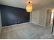 Bedroom with blue accent wall, neutral carpet, and modern light fixture at 11148 Kanturk Ct, Charlotte, NC 28213