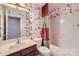 A charming bathroom with colorful wallpaper, and a shower and tub combination at 1220 Elrond Nw Dr, Charlotte, NC 28269