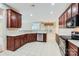 Open kitchen with stainless steel dishwasher, dark wood cabinets, and bright tile floors at 1220 Elrond Nw Dr, Charlotte, NC 28269