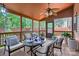 Relaxing screened porch with ceiling fan, outdoor dining set, and peaceful wooded views at 1220 Elrond Nw Dr, Charlotte, NC 28269