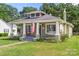 Charming craftsman style home with a porch swing, American flag, and well-manicured lawn at 124 Marion St, Clover, SC 29710