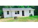 Cozy one-story home featuring white siding and a well-maintained yard, set against a backdrop of lush trees at 129 Williams Rd, Bessemer City, NC 28016