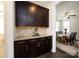 Butler's pantry features rich wood cabinetry, granite counters, and a view to the dining room at 14010 Promenade Dr, Huntersville, NC 28078