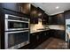 Modern kitchen with a stainless steel double oven, stylish cabinetry, and granite countertops at 14010 Promenade Dr, Huntersville, NC 28078