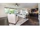 Open-concept living room with large windows, neutral decor, and a view of the kitchen at 14010 Promenade Dr, Huntersville, NC 28078