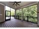 Spacious screened-in porch with a dark wood floor and views of the surrounding trees and outdoor setting at 14010 Promenade Dr, Huntersville, NC 28078