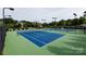Outdoor tennis courts featuring hard-surface courts, lights, fencing, and landscaping at 14010 Promenade Dr, Huntersville, NC 28078