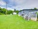 Exterior view of the house with a grassy backyard and wooden shed for possible storage at 1406 Old Puckett Pl # 14, York, SC 29745