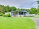 Charming single-story home with a covered porch and ramp access, set on a green lawn with surrounding trees at 1406 Old Puckett Pl # 14, York, SC 29745