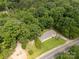 An aerial view shows the home nestled in a lush green forest, near the road at 159 Blackmon Pond Rd, Lancaster, SC 29720