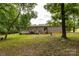 A backyard setting with lush trees, a manicured lawn, and a view of a multi-level home at 159 Blackmon Pond Rd, Lancaster, SC 29720