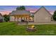 Inviting backyard featuring a pergola-covered deck and a cozy fire pit, perfect for outdoor relaxation at 159 Forest Abbey Ln, China Grove, NC 28023