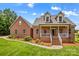 Charming brick home featuring manicured lawn, inviting front porch, and dormer windows at 159 Forest Abbey Ln, China Grove, NC 28023