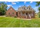 Classic brick home featuring lush green lawn, inviting porch, and dormer windows at 159 Forest Abbey Ln, China Grove, NC 28023