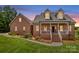 Charming brick home featuring manicured lawn, inviting front porch, and dormer windows at 159 Forest Abbey Ln, China Grove, NC 28023