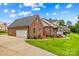 Beautiful brick exterior home with attached garage, well-manicured lawn, and inviting front porch at 159 Forest Abbey Ln, China Grove, NC 28023